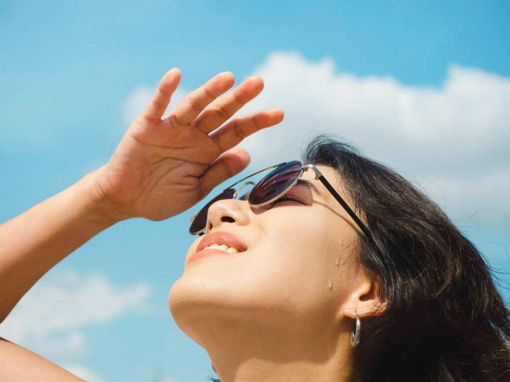 Mulher pensando em como o calor afeta a saúde dos olhos.